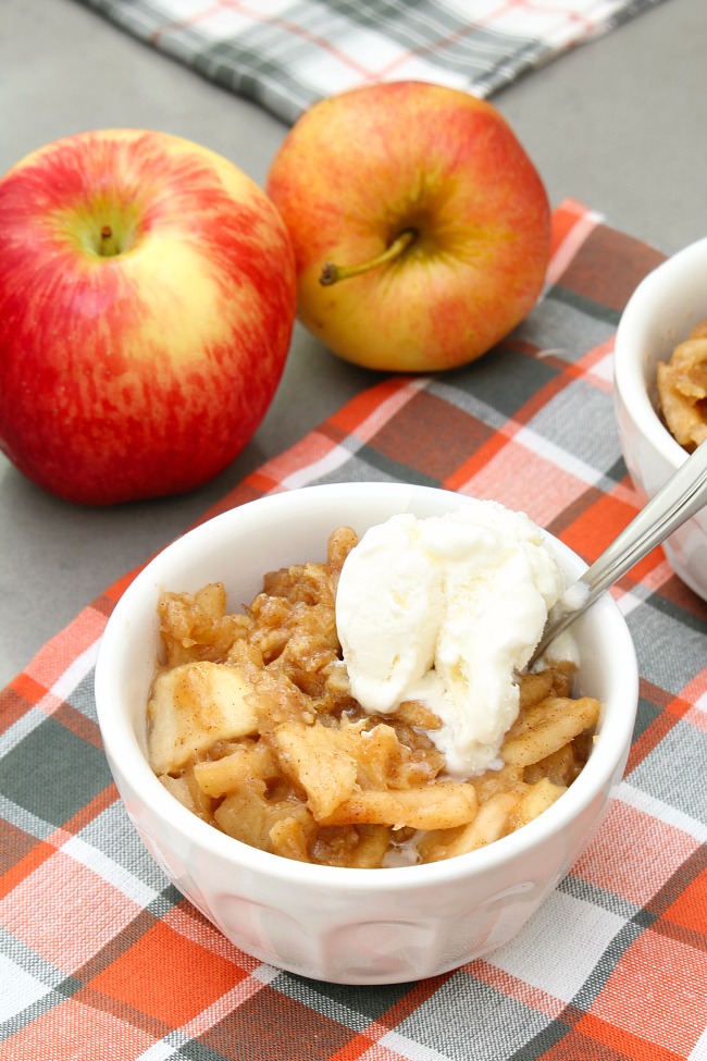 Bowls of slow cooker apple crisp topped with ice cream.