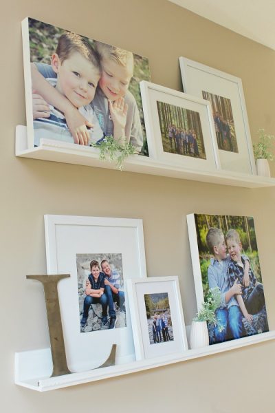 Photo gallery wall using photo ledges to cover up an ugly thermostat.