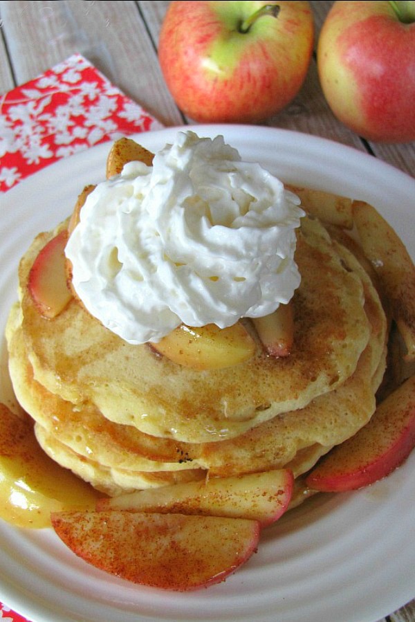 Grilled apple pie pancakes topped with whipping cream and syrup.