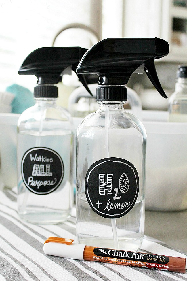 Glass spray bottles with chalkboard labels.