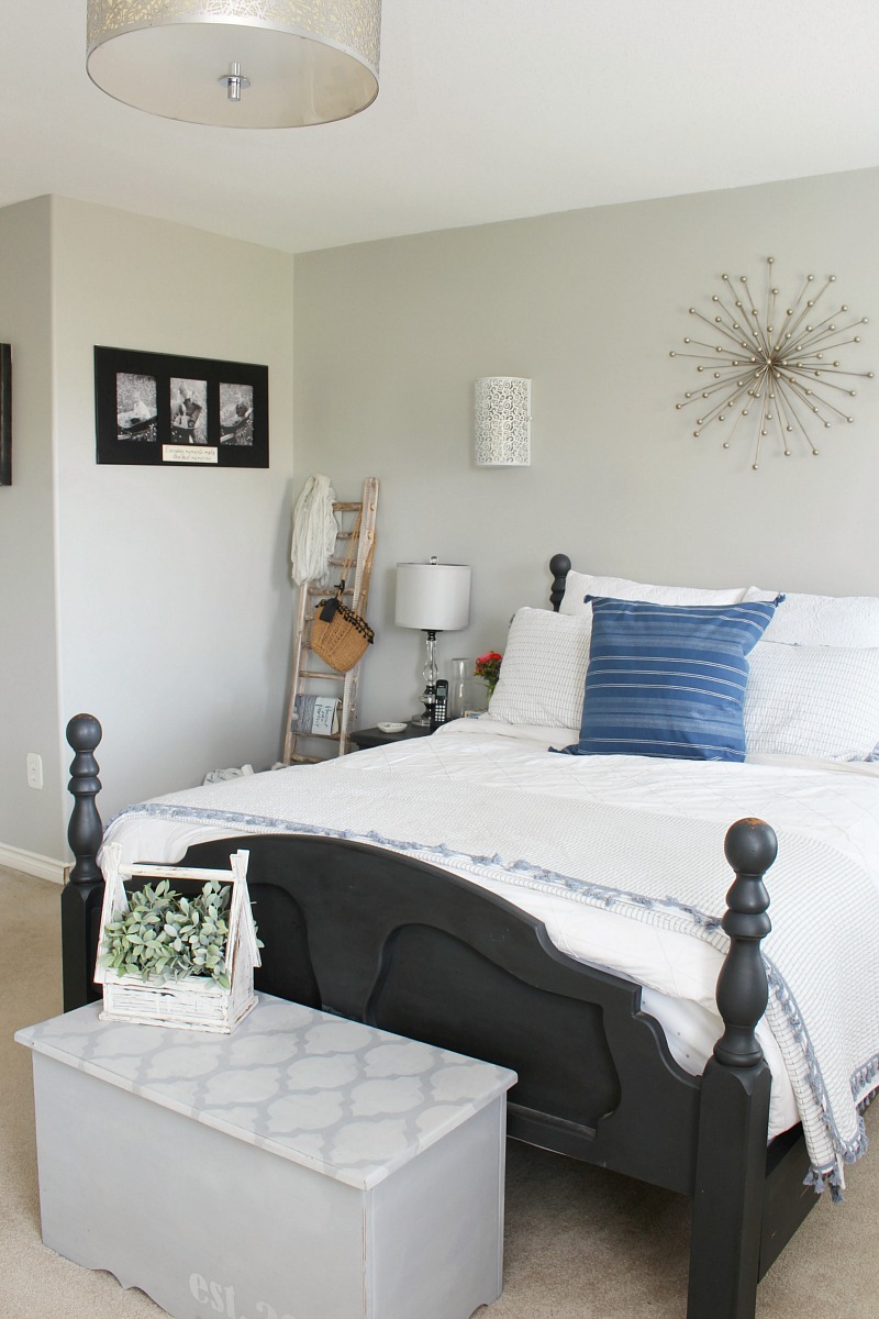 Master bedroom with black bed and white bedding.