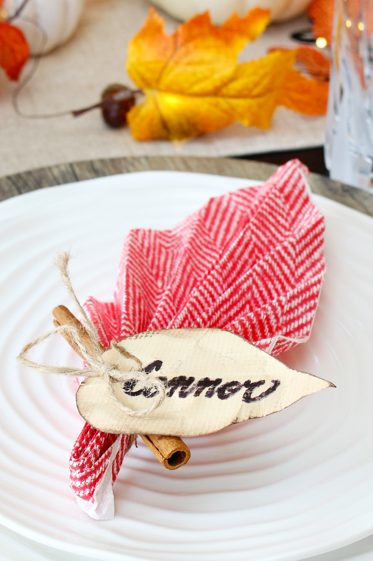 Fall leaf napkin folding with a cinnamon stick for a fall or Thanksgiving place setting.