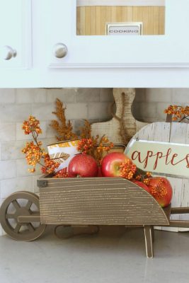 Easy fall kitchen decorating ideas. Simple ways to add some fall to your kitchen decor! Fill a small wheelbarrow with apples or other fruit for a seasonal display.