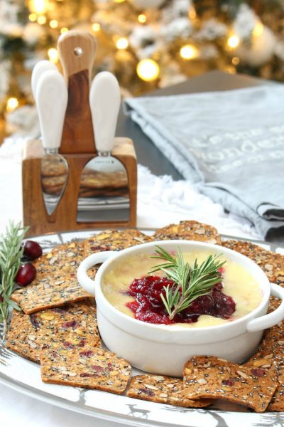 Cranberry baked brie appetizer served with cranberry crackers.