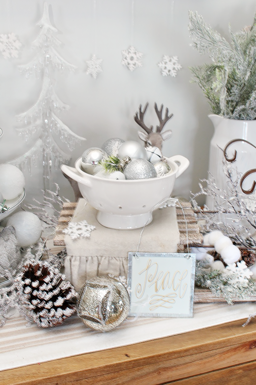 Beautiful farmhouse Christmas dining room with a snowy, winter wonderland feel. Decorated in white, greens, and metallics for that magical Christmas look.