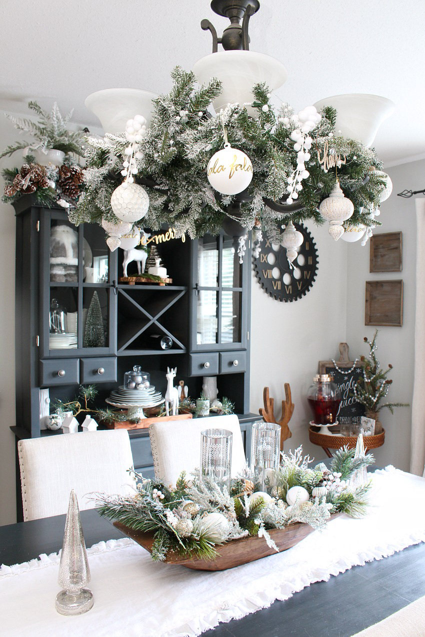 Beautiful farmhouse Christmas dining room with a snowy, winter wonderland feel. Decorated in white, greens, and metallics for that magical Christmas look.