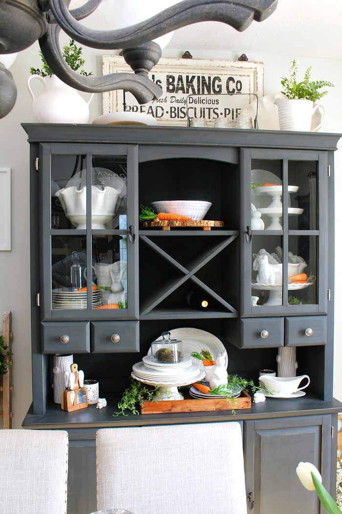 Black painted buffet and hutch decorated for Easter with white ceramic bunnies and carrots.