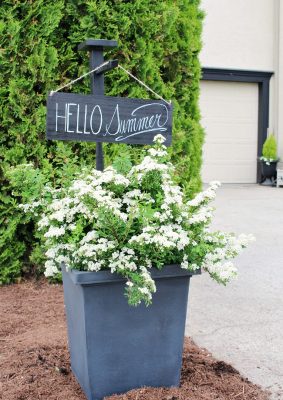 Outdoor planter with wooden holder and outdoor sign. "Hello Summer"