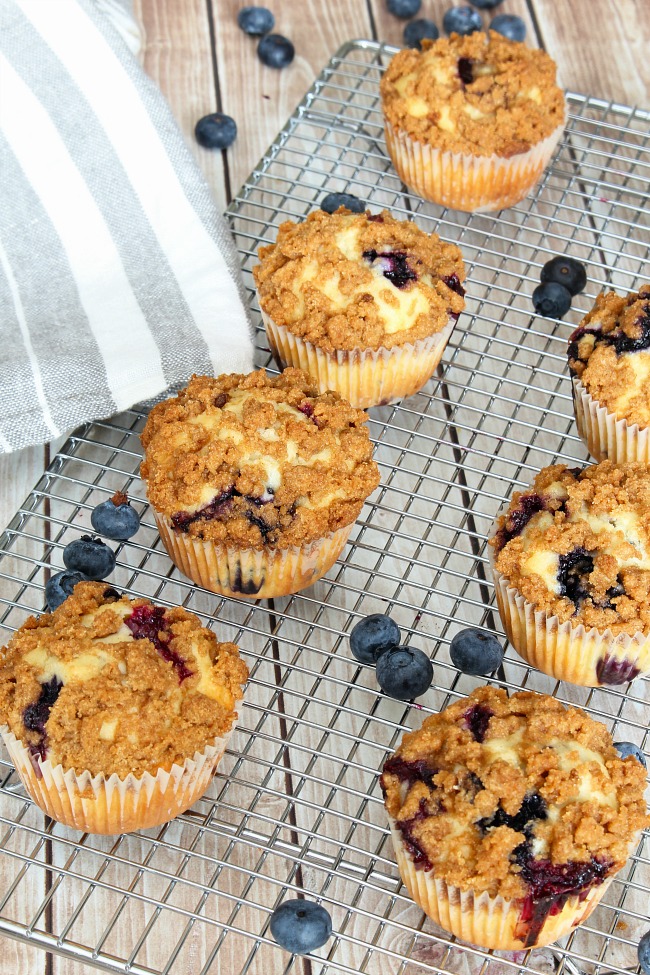 Blueberry muffins with a streusel topping on a cooling rack.
