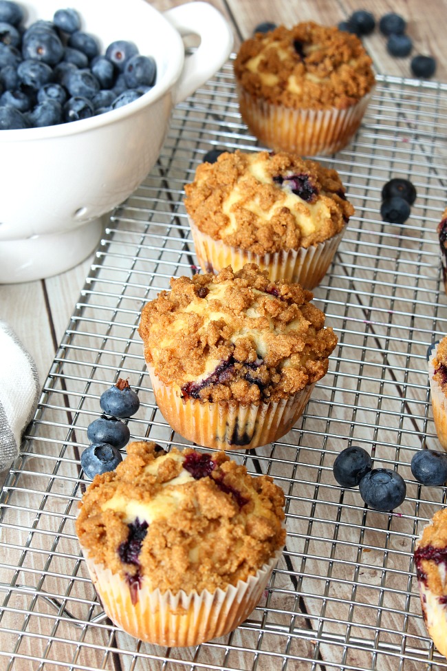 Blueberry muffins with a streusel topping on a cooling rack.