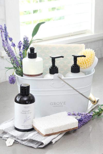 White cleaning caddy with Mrs. Meyers cleaning products in lavender and some lavender castille soap from Grove Collaborative.