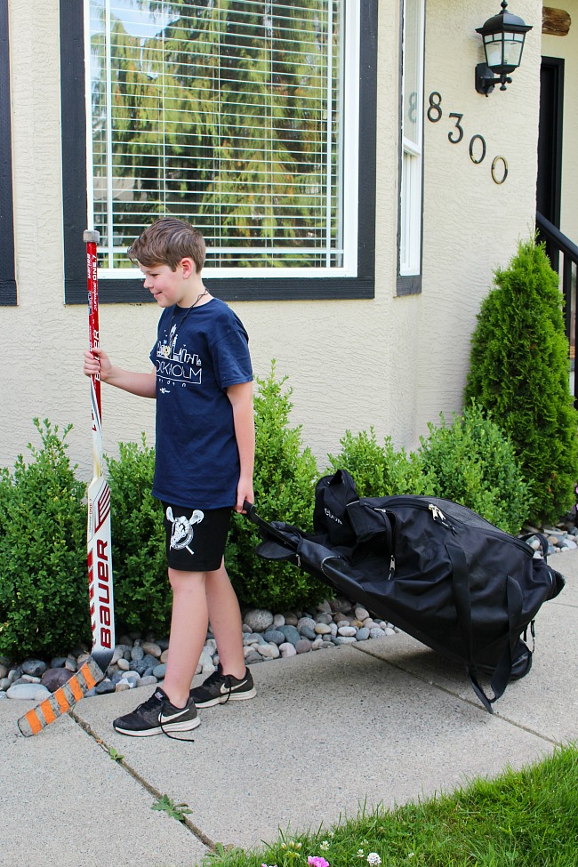 How to Clean Sports Equipment. Boy carrying a hockey bag and hockey stick.