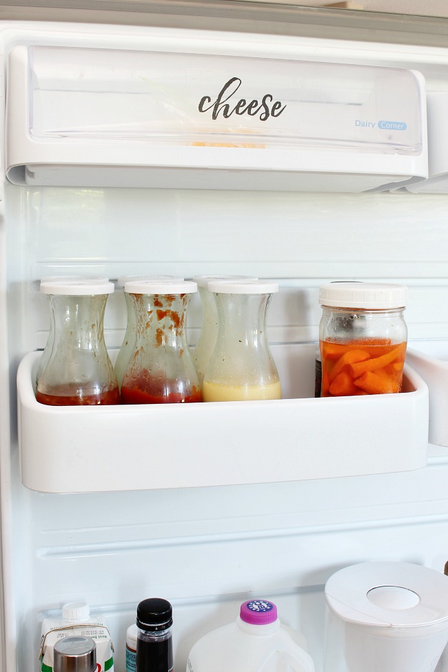 Fridge organization using Weck juice jars to hold sauces and dressings.