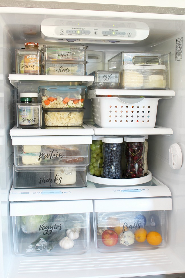 Organized fridge with bins and mason jars to keep food organized and accessible.