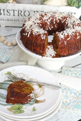 Chocolate coconut pumpkin swirl bundt cake on a cake stand with fall plates.