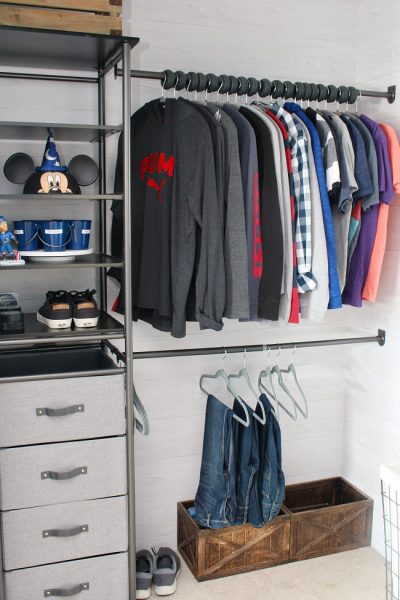 Awesome closet organizer in a teenage boys' closet. Has combination of open storage shelves and closed storage with pull out drawers.