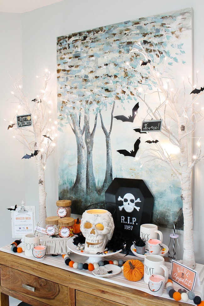 Halloween hot chocolate bar with lighted trees and velvet bats.