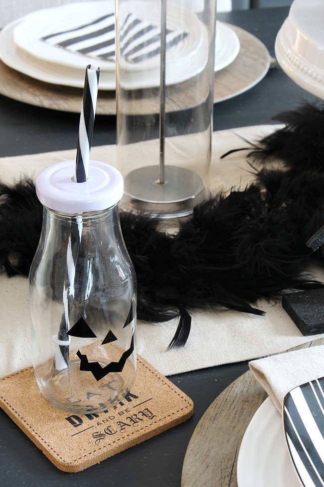 Black and white Halloween decor ideas for a tablescape with glasses using black vinyl for jack-o-lantern faces.