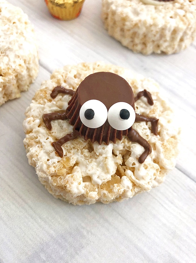 Rice Krispie treats topped with a mini peanut butter cup spider for a fun Halloween treat.
