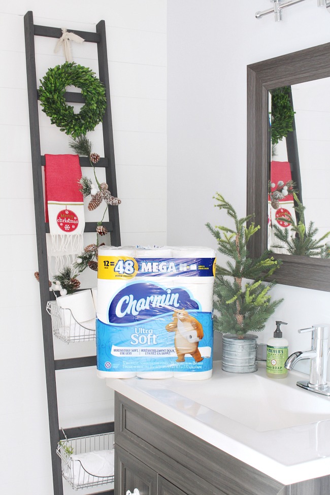Farmhouse style bathroom decorated for Christmas and stocked with cleaning supplies for holiday parties.