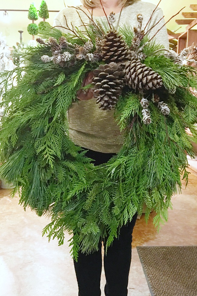 DIY Christmas wreath made with fresh greenery, and pinecones.