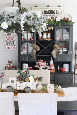 Farmhouse style dining room with black hutch decorated for Christmas in red and white.