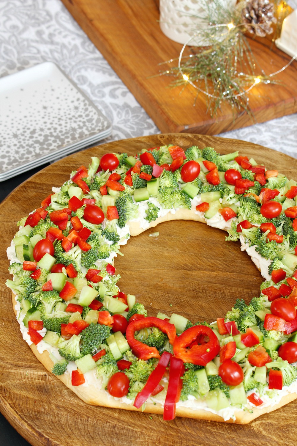 Christmas wreath veggie pizza on a cutting board.