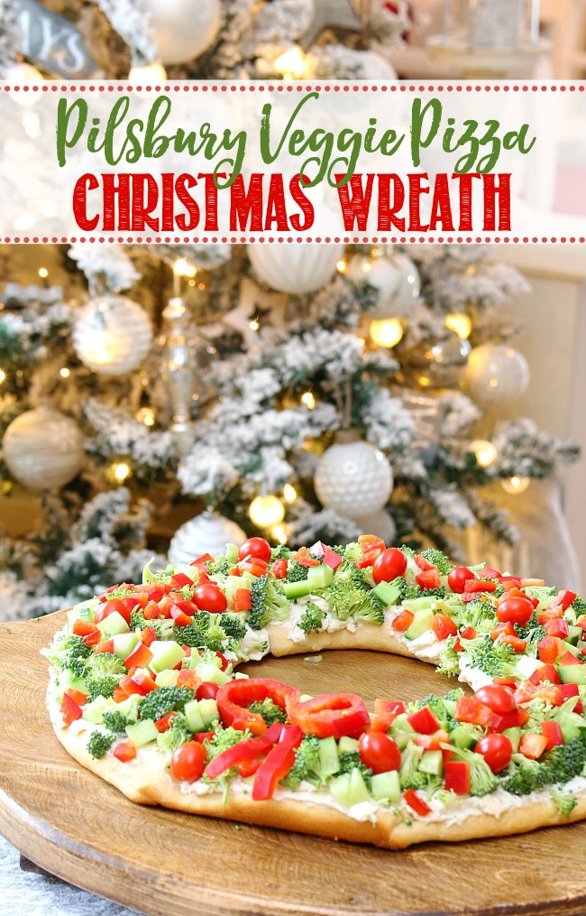 Cute veggie pizza Christmas wreath appetizer on a wood cutting board.