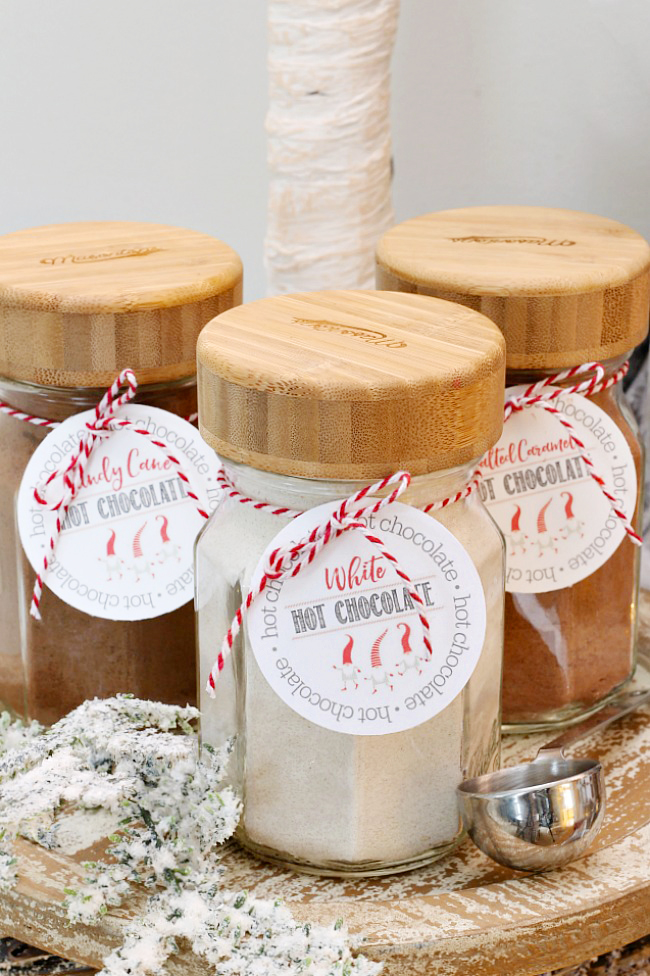 Mason jars with bamboo lids filled with various hot chocolate mixes for a fun and easy Christmas hot chocolate bar.