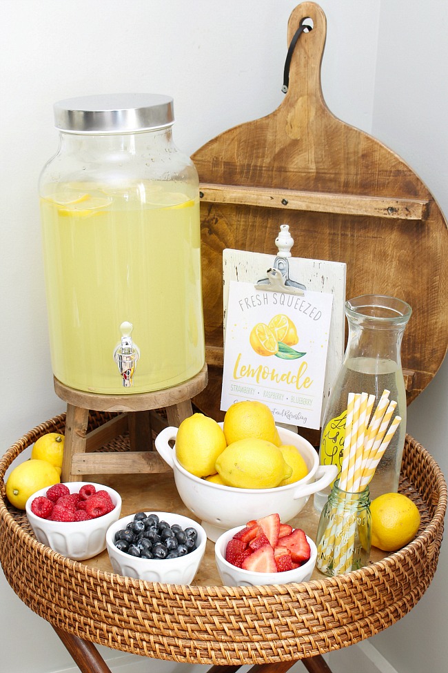 Lemonade bar with lemonade and fresh fruits. Free lemonade stand printables.