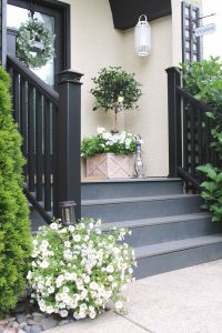 Traditional front porch with a various white flowers.