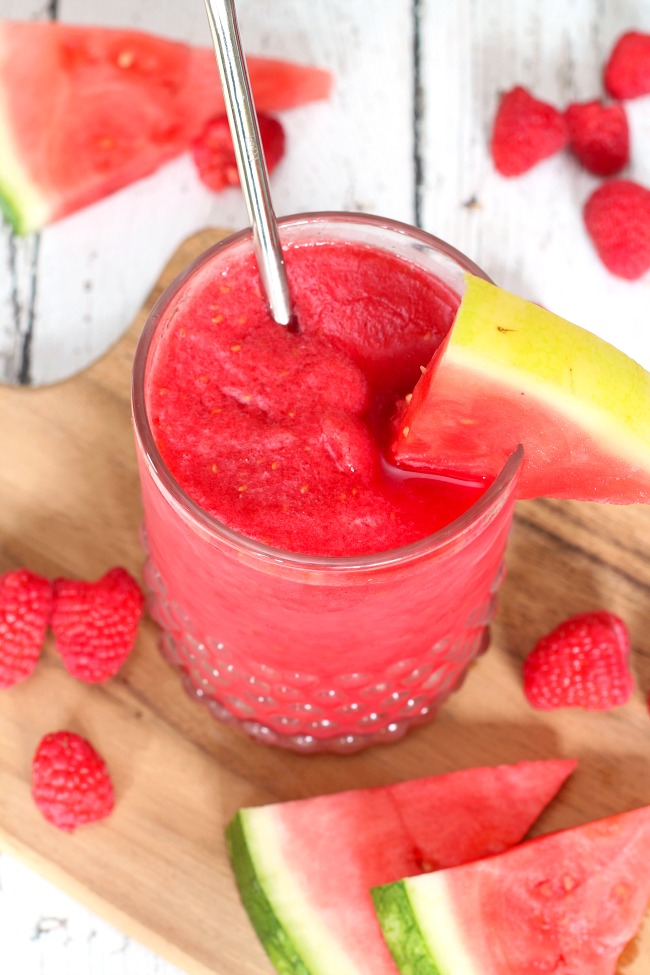 Delicious raspberry watermelon slush in a glass with a metal straw.