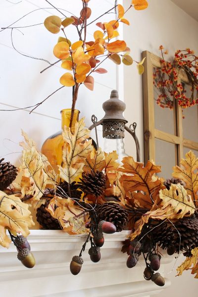 Beautiful amber glass bottles and golden fall stems create a beautiful fall mantel.