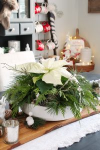 Simple DIY Christmas centerpiece idea with a poinsettia and fresh greenery.