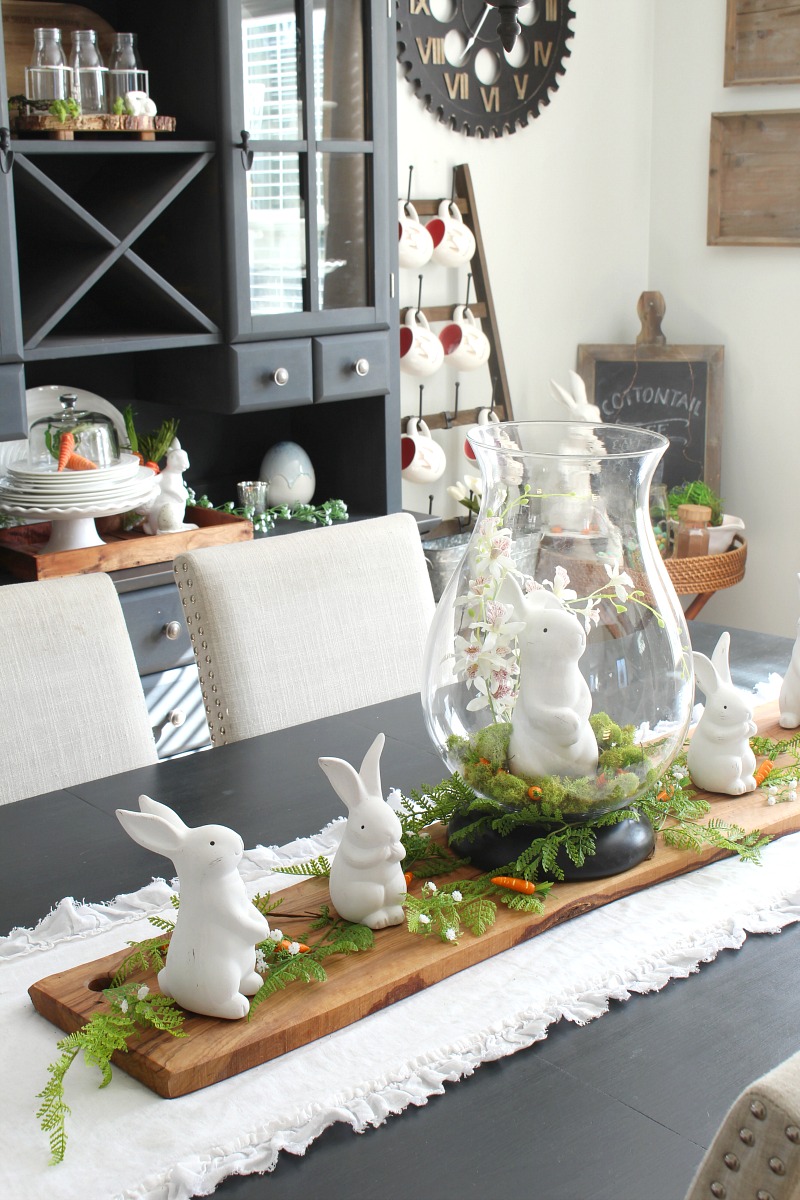 Cute Easter centerpiece with glass hurricane vase and ceramic bunnies.