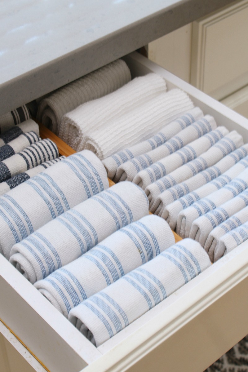 Kitchen drawer with dish towels stored horizontally.