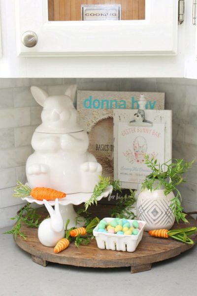 Wood tray with Easter kitchen decor items in a white kitchen.