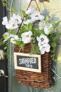 Summer basket wreath with white flowers, greenery, and chalkboard sign.