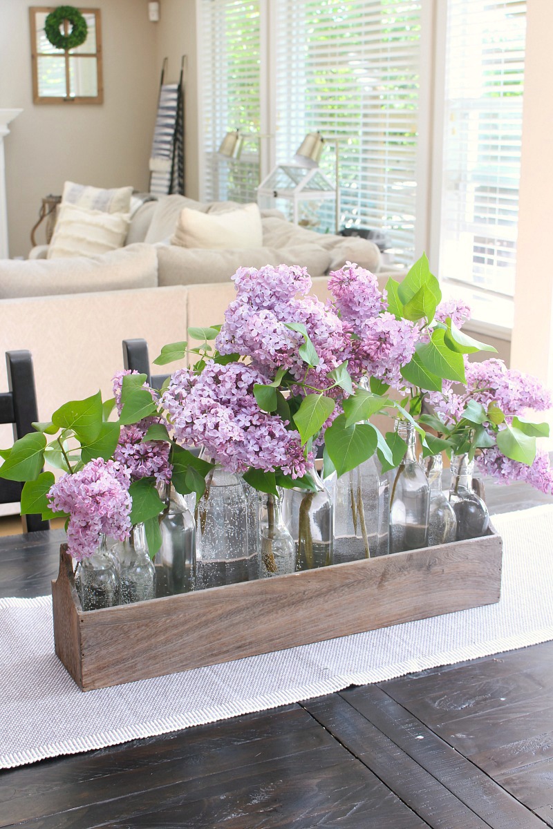 Lilacs used in a pretty centerpiece on a kitchen table.