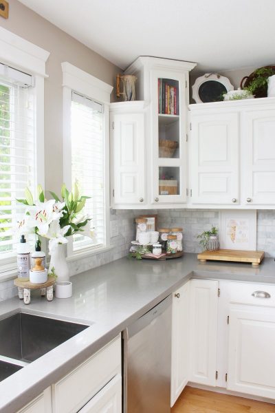 White kitchen with grey quartz countertops decorated for summer.