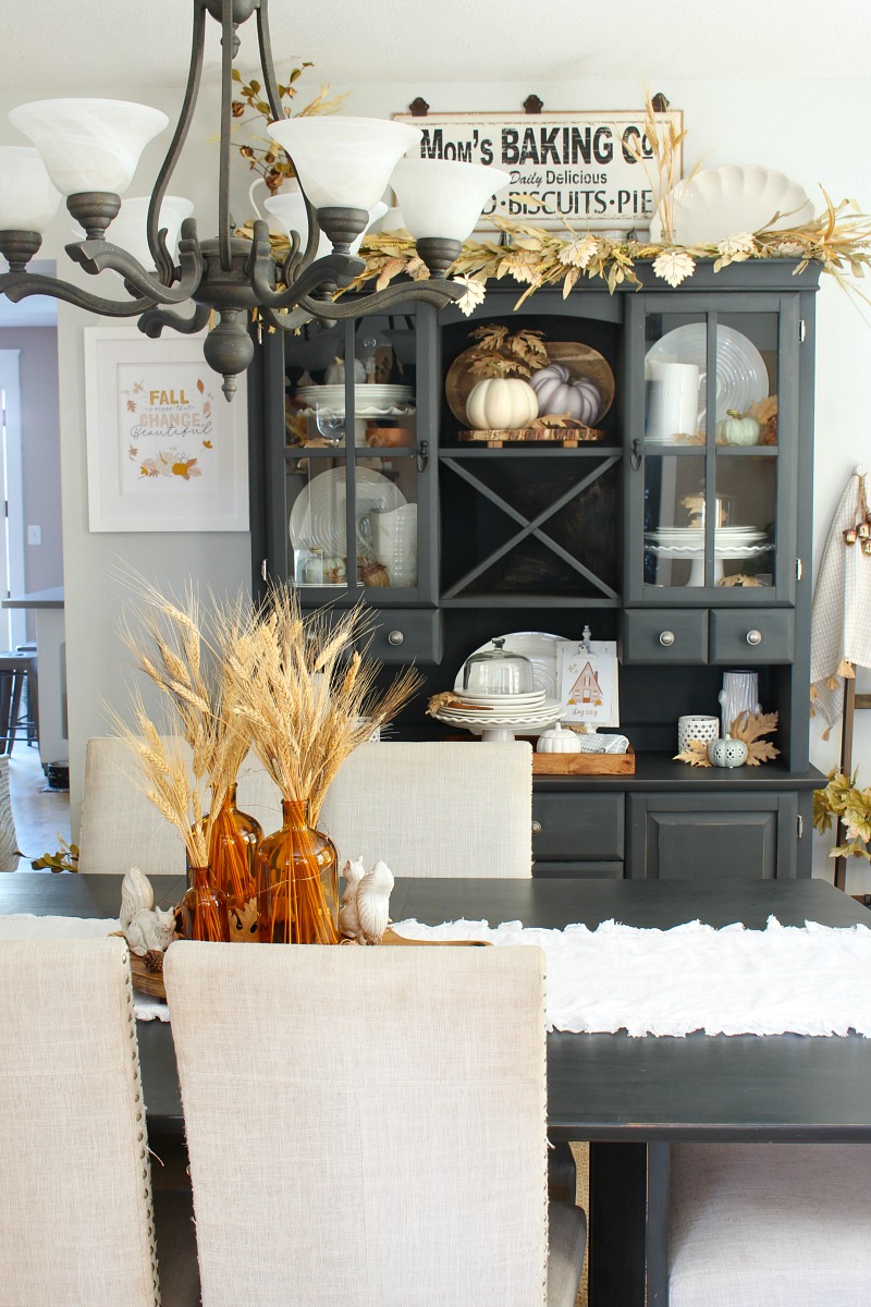 Beautiful farmhouse style dining room decorated for fall with neutral fall colors.