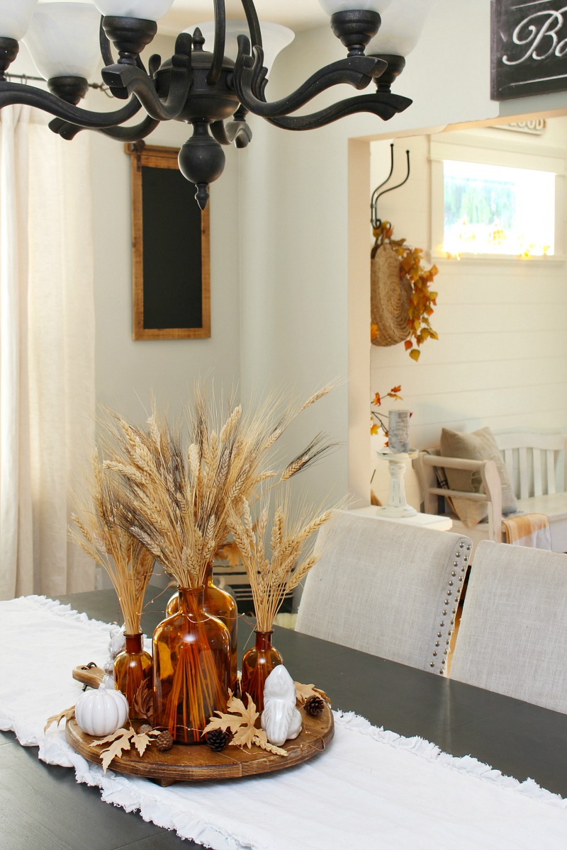 Fall centerpiece with amber glass and wheat.