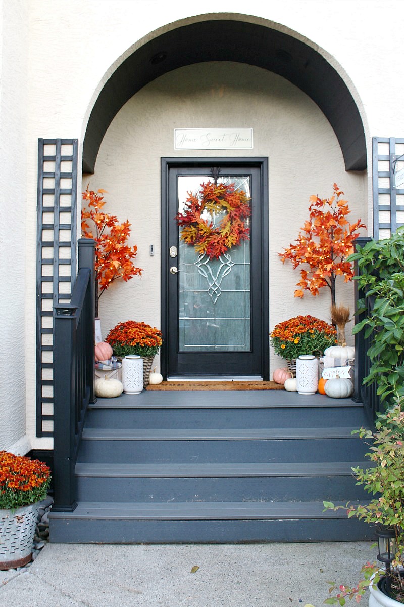 Colorful front porch with lighted maple trees and orange mums.