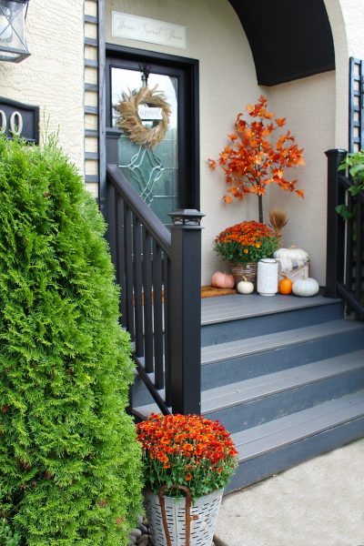 Colorful front porch with lighted maple trees and orange mums.