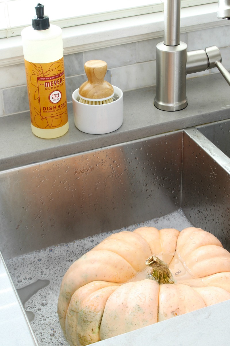 Pumpkin being washed in sink to make it last longer.