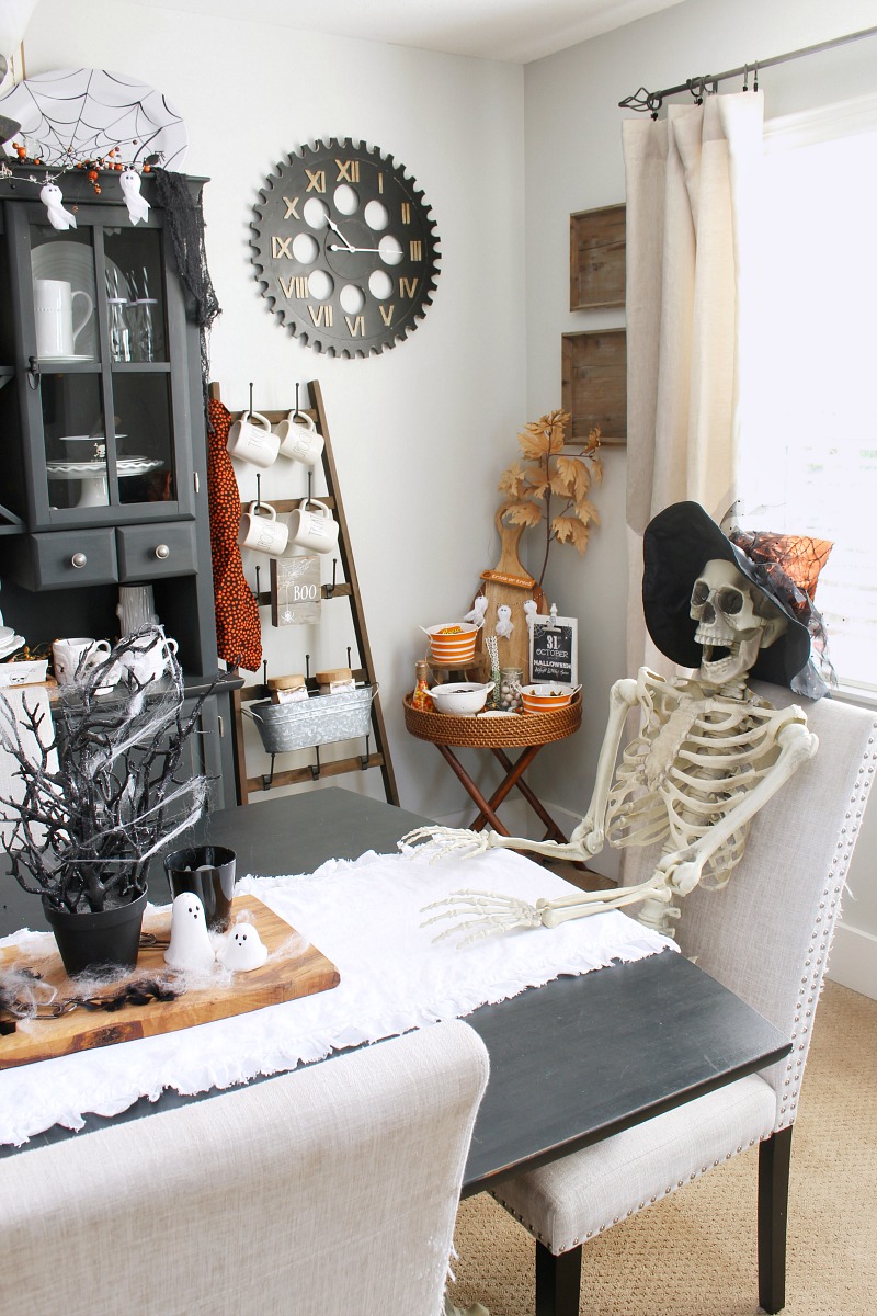 Dining room space decorated for Halloween with skeleton.