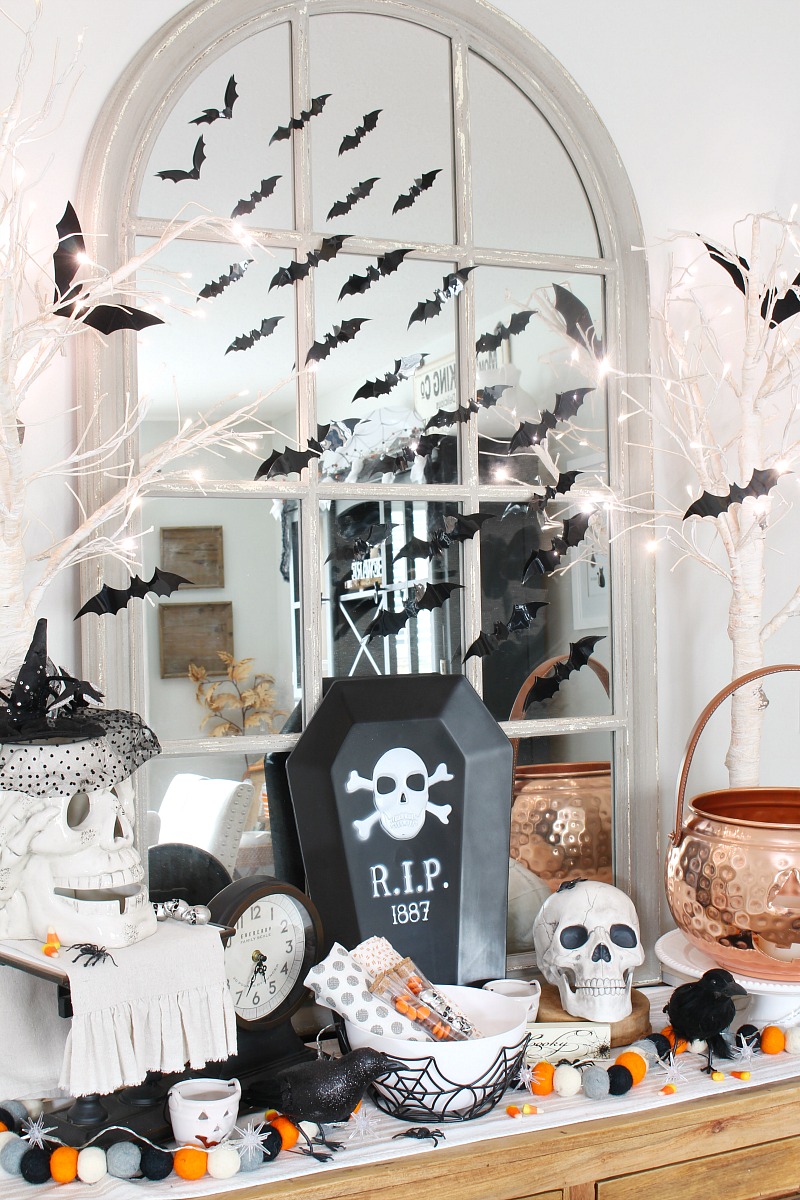 Dining room sideboard decorated for Halloween with bats and skeletons.