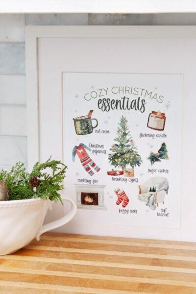 Cozy Christmas Essentials free Christmas printable in a frame with a bowl of ornaments.