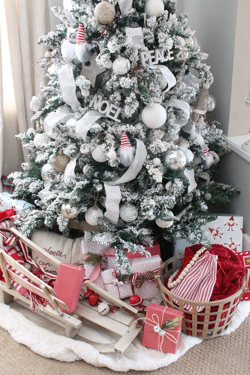 Flocked Christmas tree decorated with white and silver with a few pops of red.