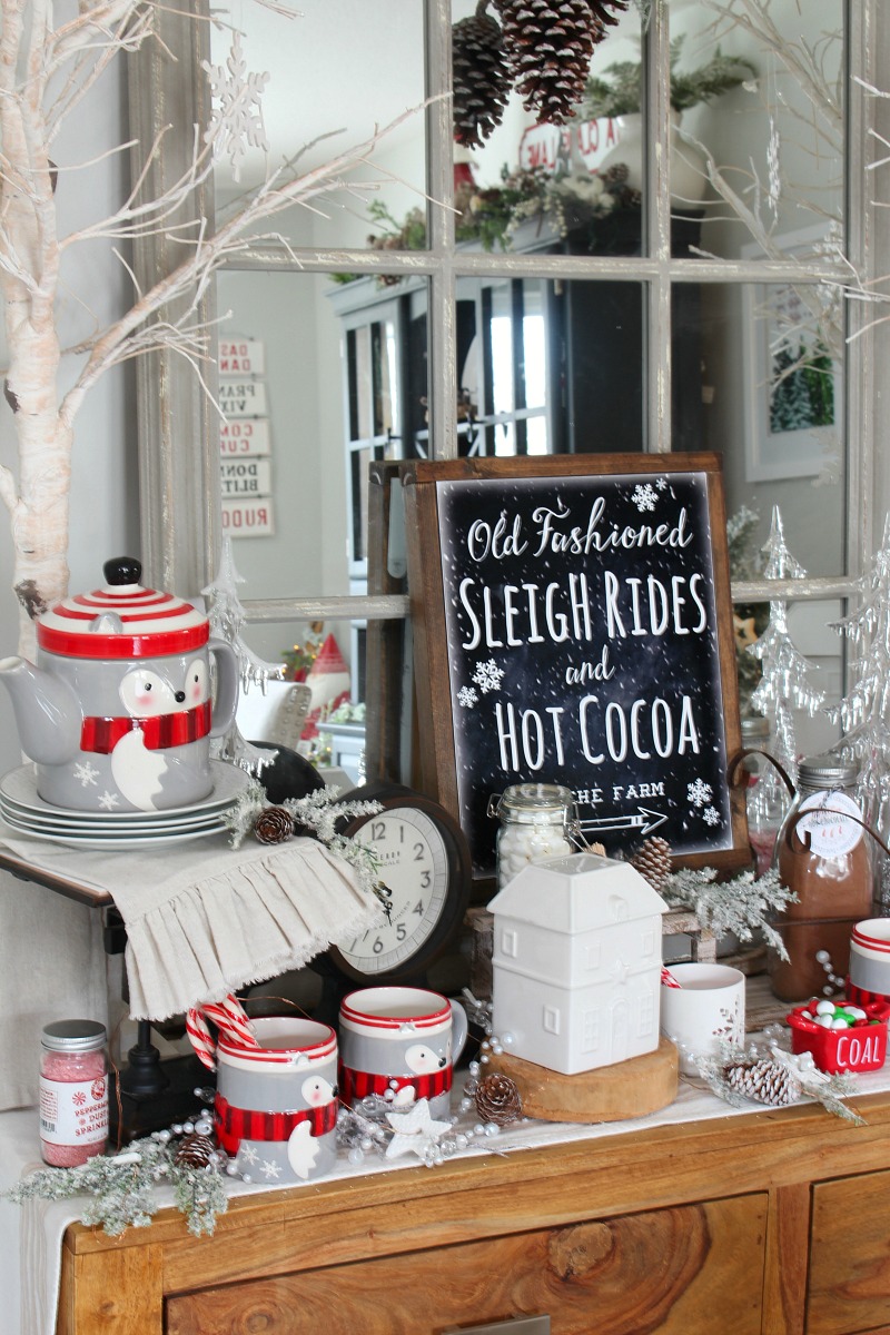 Side board in a dining room decorated for Christmas as a hot chocolate bar.